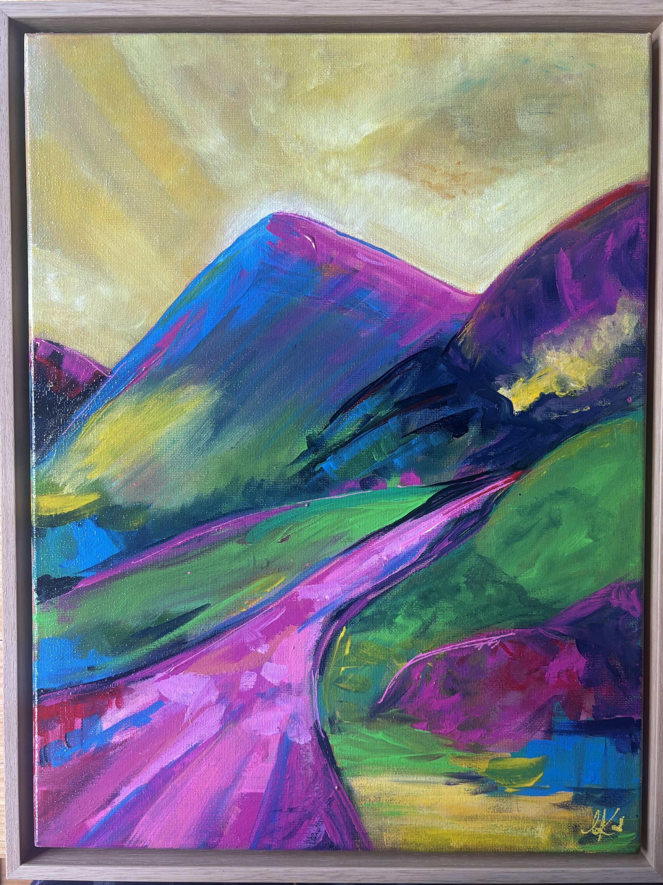 Expressionist landscape of a vivid blue mountain peak streaked with magenta and green, rising from green hillsides under a warm yellow and soft pink sky.